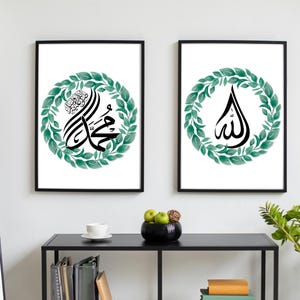 May include: Two framed art prints with Islamic calligraphy. Each print has a black frame and a white background. One print displays the name of the Prophet Muhammad, and the other displays the word Allah, both in black calligraphy, surrounded by a green wreath.