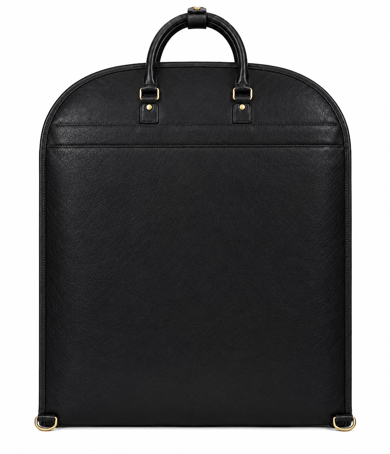 K&ouml;nnte beinhalten: Eine schwarze Kleiderschutzh&uuml;lle mit abgerundeter Oberseite, ausgestattet mit einem einzelnen Tragegriff und goldfarbenen Metallbeschl&auml;gen. Die Tasche hat eine strukturierte Oberfl&auml;che, eine horizontale Naht im oberen Bereich und zwei kleine Metallringe.