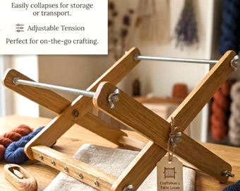 May include: A wooden Craftsman's Table Loom with a compact folding design. The loom is made of light-colored wood and features adjustable tension. The image also shows yarn and a folded cloth.