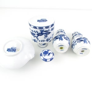 May include: A set of blue and white porcelain salt and pepper shakers with a floral design. The shakers are made in Japan and feature the text "Villeroy & Boch" on the bottom.