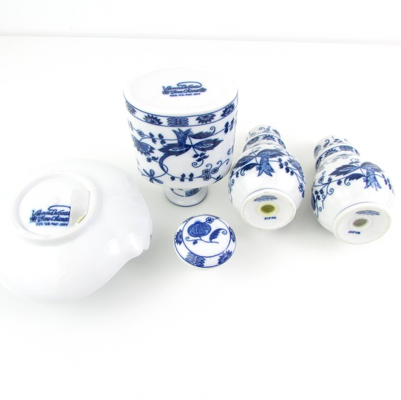 May include: A set of blue and white porcelain salt and pepper shakers with a floral design. The shakers are made in Japan and feature the text "Villeroy & Boch" on the bottom.