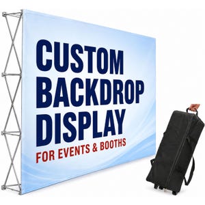 May include: A large rectangular backdrop display with a light blue gradient background and the dark blue text CUSTOM BACKDROP DISPLAY and red text FOR EVENTS & BOOTHS. It features a silver metal collapsible frame and a black rolling carrying case.