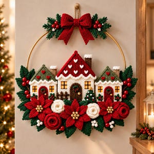 May include: A circular wall hanging featuring a gold metal hoop decorated with crocheted elements. Three small houses with red roofs and white walls are centered, surrounded by red poinsettias, green leaves, red berries, and a red bow.