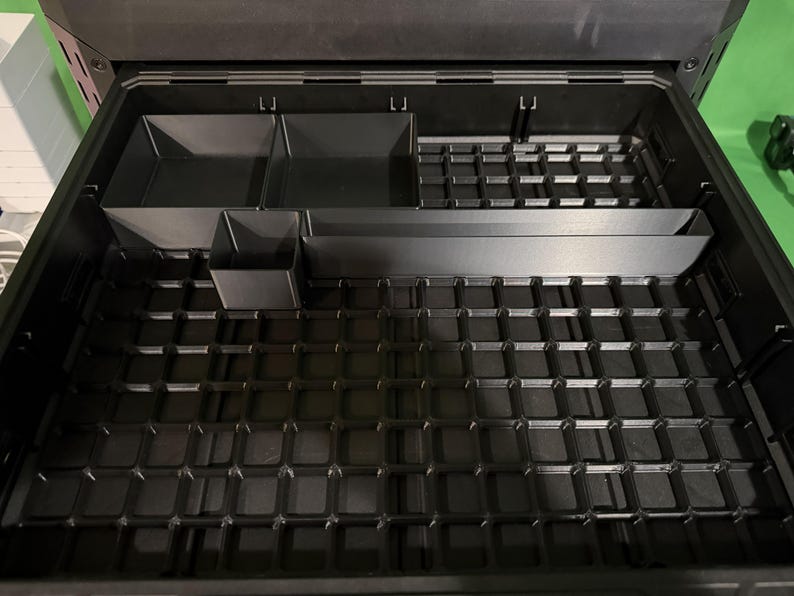 a black plastic container with multiple compartments, designed to hold and organize various items.