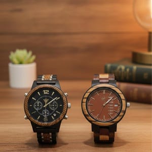Può includere: Due orologi da polso in legno, neri e marroni. Uno ha un quadrante nero con sottoquadranti cronografici, l'altro un quadrante marrone. Entrambi hanno lunette e cinturini in legno, offrendo un'estetica naturale.