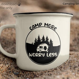 Peut inclure: Mug de camping en émail crème avec un bord et une anse noirs. Le mug présente un graphisme noir d'une caravane, d'arbres et les mots "Camp More Worry Less" dans un cercle. Le texte sur le mug indique "Téléchargement instantané" et "Camping SVG Quote".