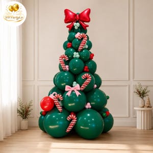 Puede incluir: Un árbol de Navidad construido con globos de color verde oscuro, decorado con globos de bastones de caramelo a rayas rojas y blancas, un gran lazo rojo de aluminio en la parte superior, un lazo rosa claro y un globo rojo brillante en la base.
