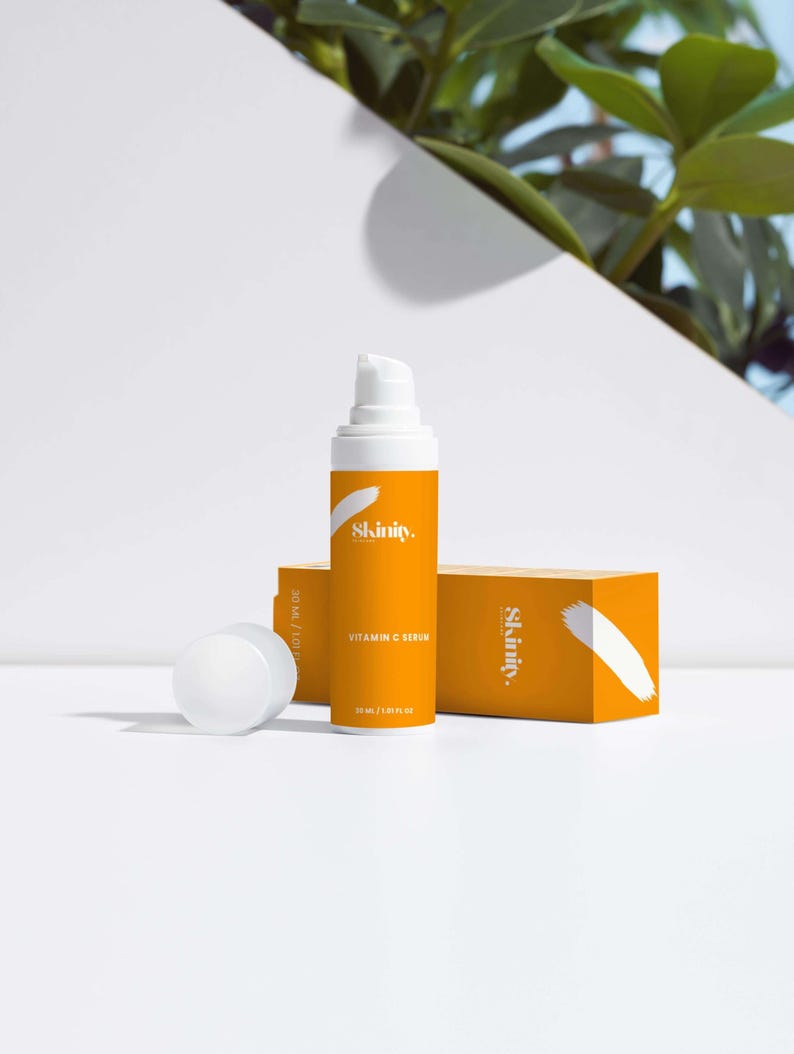 K&ouml;nnte beinhalten: Eine orangefarbene Vitamin-C-Serumflasche und -box mit dem Markennamen "Skinity" in Wei&szlig;. Die Flasche ist wei&szlig; mit einem orangefarbenen Etikett und einer wei&szlig;en Pumpe. Die Box ist orange mit einem wei&szlig;en Diagonalkreuz.