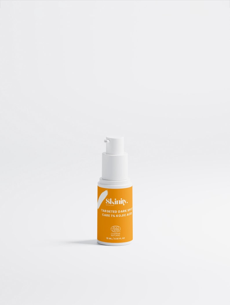 May include: A white and orange skincare product bottle with a pump dispenser. The label reads "Skinity. Targeted Dark Spot Care 1% Kojic Acid". The bottle contains 15 ml / 0.51 fl oz of product.