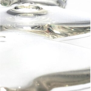 May include: Abstract image of clear, liquid droplets with a reflective, metallic sheen. The droplets are arranged in a pattern, creating a sense of depth and texture against a white background. The image has a soft focus.