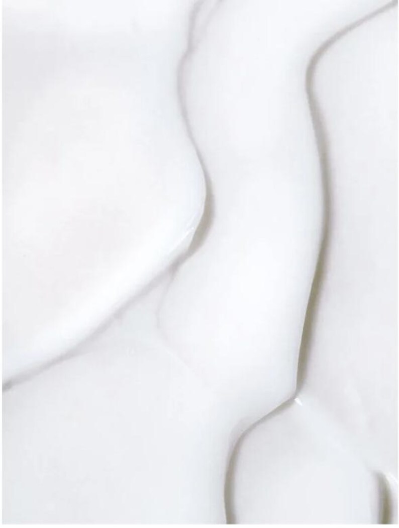 May include: Close-up of a white, flowing, and textured surface. The image shows smooth, curved shapes with highlights and shadows, creating a sense of depth and movement. The overall effect is clean and minimalist.