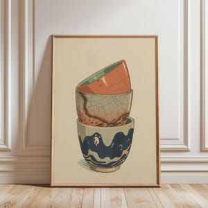 May include: An art print featuring three stacked ceramic bowls. The top bowl is orange with a green interior, the middle bowl is gray with a cracked pattern, and the bottom bowl is blue and white with a wave design.