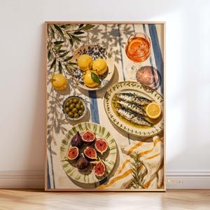 Könnte beinhalten: Ein gerahmter Kunstdruck mit einem mediterranen Tischgedeck, bestehend aus einer Schale mit gelben Zitronen, einer kleinen Schale mit grünen Oliven, einem Teller mit aufgeschnittenen Feigen und einer Platte mit gebratenen Sardinen.