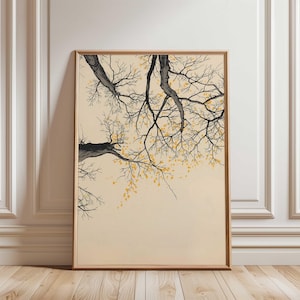 May include: Framed art print depicting a tree branch with black and grey bark and yellow leaves. The artwork is set against a cream background, with a wooden frame.