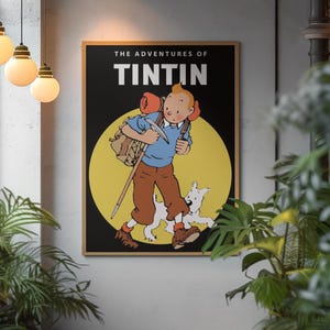 May include: A framed poster featuring Tintin and Snowy from "The Adventures of Tintin." The artwork depicts Tintin in a blue shirt and brown pants, carrying a backpack and walking stick, with Snowy running alongside. The background is a yellow circle against a black backdrop.