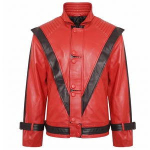Puede incluir: Chaqueta de cuero roja con detalles negros. La chaqueta presenta un cuello alto, hombreras y un diseño de rayas negras en forma de V en el pecho. Tiene cierre de botones y correas negras en las mangas y la cintura.