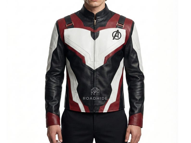 Puede incluir: Chaqueta de cuero negra, blanca y roja con cuello alto y cierre de cremallera. La chaqueta presenta el logotipo de los Vengadores en el pecho y la palabra "ROADHIDE" impresa en la parte delantera. La chaqueta tiene un dise&ntilde;o &uacute;nico con detalles en blanco y rojo.