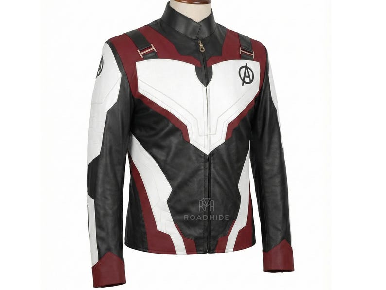 Puede incluir: Chaqueta de cuero negra, blanca y burdeos con cuello alto y cierre de cremallera. La chaqueta presenta paneles blancos en el pecho y las mangas, detalles en burdeos y un logotipo de los Vengadores. Una prenda de abrigo elegante.