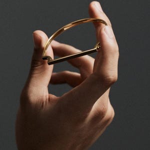Scharnierende armband van 18k verguld zilver, dunne, eenvoudige armband met architectonische staafjes, moderne geometrische stapelarmband, ingetogen luxe polssieraad voor de welgestelden.