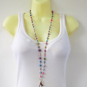 May include: A colorful beaded lanyard with a silver chain and a swivel clasp. The beads are made of various colors and patterns, including pink, blue, green, and purple.