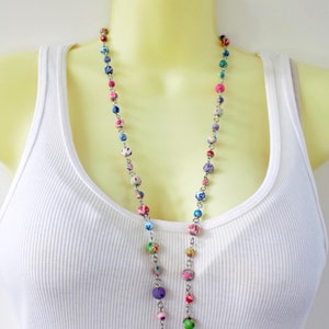 May include: A long necklace with colorful patterned beads and a silver chain.