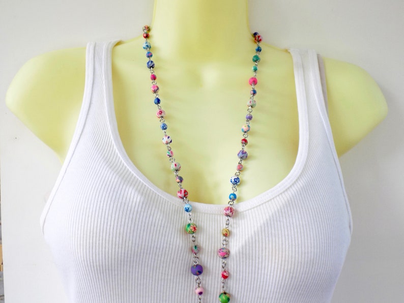May include: A long necklace with colorful patterned beads and a silver chain.