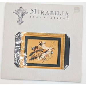 May include: A Mirabilia cross-stitch kit featuring a framed design with a detailed, colorful illustration. The artwork depicts a figure with a long white beard, ornate clothing, and decorative elements. The kit includes the Mirabilia logo.