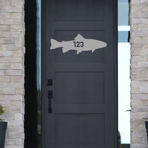 May include: A white ceramic mug with a black handle and the text "But First, Coffee" in a black, bold font. The mug is sitting on a white surface.