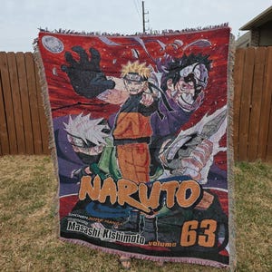 May include: A woven throw blanket featuring characters from the anime series Naruto. The blanket has a red border and displays the title "Naruto" in large orange letters, along with other characters and text from the manga.