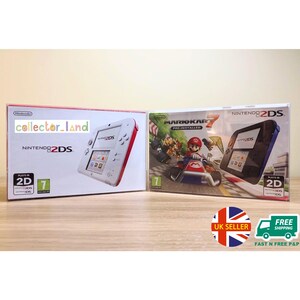 以下が含まれることがあります： 2つのNintendo 2DSゲーム機がオリジナルのパッケージに入っています。1つの箱には白と赤のコンソール、もう1つにはマリオカート7が表示されています。箱にはNintendo 2DSのロゴとゲームの詳細が表示されています。