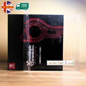 Puede incluir: Una caja negra con texto rojo y blanco que dice "Xenoblade Chronicles Definitive Edition" y un logotipo de Nintendo Switch. La caja está en una funda de plástico transparente. También se ven las palabras "Collector's Set Collector".
