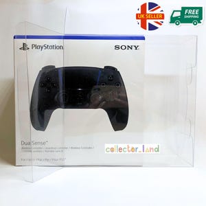 May include: A black PlayStation DualSense wireless controller in its original packaging. The box features the PlayStation and Sony logos, with the words "DualSense" and "Wireless Controller" visible. The controller is displayed inside a clear plastic case.