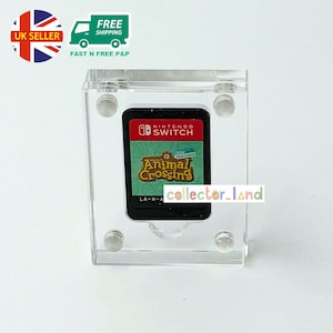 May include: A Nintendo Switch game cartridge for "Animal Crossing: New Horizons" in a clear acrylic display case. The cartridge has a red and black label with the game title. The case has four clear circular supports. The image also includes the text "UK SELLER" and "FREE SHIPPING".