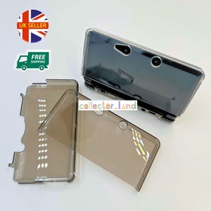 May include: Three transparent, smoky-grey phone cases. The cases are designed for a specific phone model, with cutouts for the camera and other features. The cases are made of a clear, flexible material.