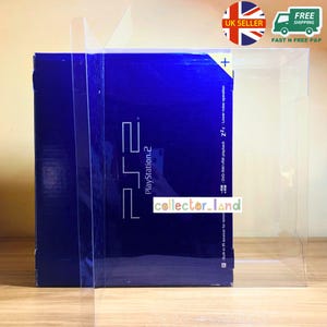 Peut inclure: Une boîte bleue de console PlayStation 2 est présentée dans un boîtier en plastique transparent. La boîte affiche le logo PlayStation 2 et du texte. Le boîtier a un autocollant vendeur britannique et un autocollant de livraison gratuite.