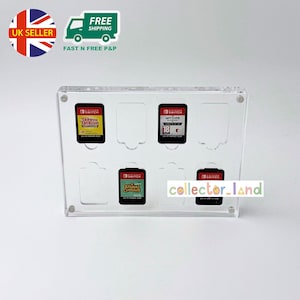 May include: Clear acrylic game cartridge holder for Nintendo Switch games. The holder displays four game cartridges, including "Tairoine Tatsusin", "Witcher", and "Animal Crossing". The text "collector_land" is visible on the holder.