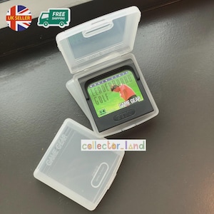 以下が含まれることがあります： 透明なプラスチックケースに入った「Leaderboard Golf」の黒いGame Gearカートリッジ。カートリッジには、ゲームタイトルとゴルファーの画像が描かれた緑と赤のラベルが付いています。ケースは開いており、別の空のケースが見えます。