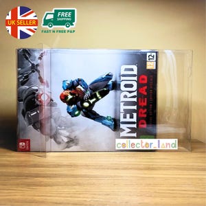 以下が含まれることがあります： Nintendo Switch用メトロイドドレッドスペシャルエディションのビデオゲーム。ゲームボックスには、青と赤のスーツを着たキャラクターのダイナミックなイラストが描かれています。ゲームは透明なプラスチックケースに入っています。