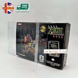 Puede incluir: Una caja de juego de Nintendo GameCube para "The Legend of Zelda: Four Swords Adventures" en una funda protectora transparente. La ilustración de la caja presenta personajes del juego. La caja es negra con texto verde y dorado. El juego tiene una clasificación de 3+.