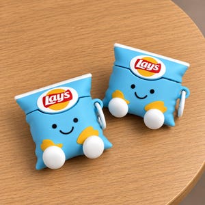 May include: Two light blue silicone cases for wireless earbuds, each shaped like a Lay's potato chip bag. The cases feature a smiling face, yellow chip accents, white circular feet, and the red and yellow Lay's logo printed on the front surface.