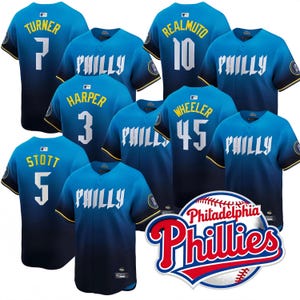 May include: A collection of Philadelphia Phillies baseball jerseys in shades of blue, featuring player names and numbers in white and yellow. The jerseys display the word "PHILLY" prominently. The Phillies team logo is also visible.