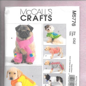 Può includere: Un cartamodello per vestiti da cane, che presenta una varietà di stili, tra cui una sciarpa rosa, un gilet giallo e arancione, una camicia a righe blu e bianche e una camicia a pois rossi e bianchi. Il cartamodello è per la taglia OSZ ed è di McCall's Crafts.