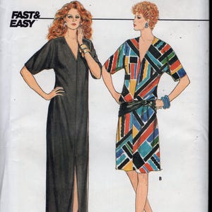 May include: A vintage Butterick sewing pattern featuring two dress designs. One is a long, black, V-neck dress with a front slit. The other is a colorful geometric print dress with a black belt. The pattern includes the text "FAST & EASY".