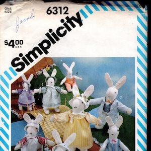 May include: A Simplicity sewing pattern for making seven bunny rabbit toys. The pattern number is 6312 and the price is $4.00. The bunnies are dressed in various outfits, including a yellow dress, a blue and white striped dress, a blue and white striped overall, and a blue suit.