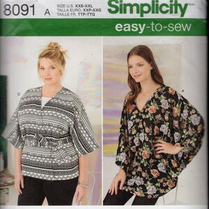 May include: Simplicity sewing pattern 8091 features various tops. The pattern includes a black and white patterned top, a floral print top, and other designs. The text "easy-to-sew" is visible. The pattern is designed and printed in the USA.