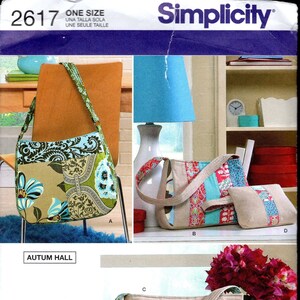 May include: A sewing pattern for three different bags. The bags are made of patchwork fabric with floral and geometric designs in shades of blue, green, pink, and brown. The pattern is called "Simplicity 2617" and is designed by Autum Hall.