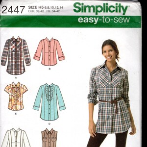 Könnte beinhalten: Simplicity Schnittmuster 2447 für Hemden in den Größen 6-14. Die Hülle zeigt sechs Varianten von Hemden mit Knopfleiste, verschiedenen Ärmellängen, Kragenformen und Rüschen sowie ein Foto eines karierten Hemdes.