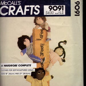 May include: McCall's Crafts pattern 9091 featuring soft-sculptured doll clothes. The cover shows four dolls of different skin tones and hairstyles, with a ruler showing 18" (46cm) and 23" (58.5cm) sizes. The dolls are wearing various outfits.