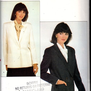 May include: A Very Easy Very Vogue sewing pattern envelope, number 8083, size 14. The front displays two blazer designs: one in white worn with a tan scarf, and one in dark navy with a white blouse. Text includes '8083', 'Very Easy Very Vogue', and 'TAILLE SIZE 14'.