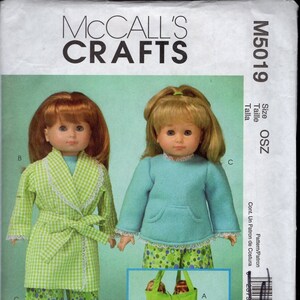 May include: A sewing pattern for making doll clothes and accessories. The pattern includes instructions for making a green and white checkered robe, green and white polka dot pajamas, a green tote bag, and a pink pillow. The pattern is for 18-inch dolls. The pattern number is M5019.